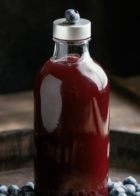 Здоровый красный напиток в расположении стеклянных бутылок
