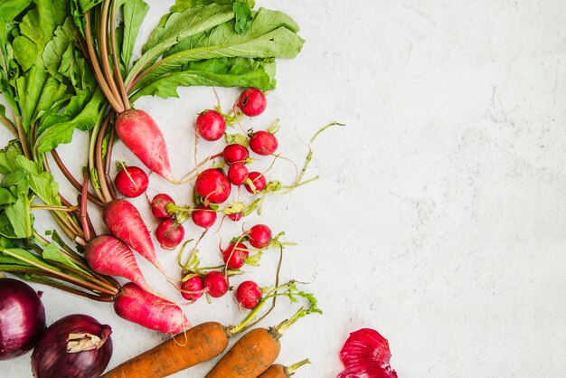 Healthy root vegetables on marble backdrop