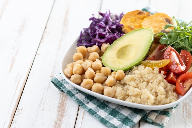 Free photo healthy salad with avocadolettucetomato and chickpeas on white wooden table