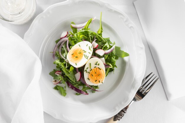 Healthy salad with egg on a white plate arrangement