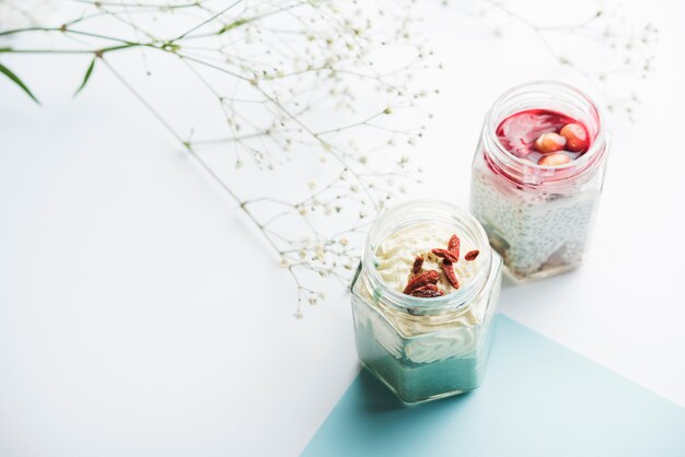 Healthy smoothie jars and gypsophila on white background