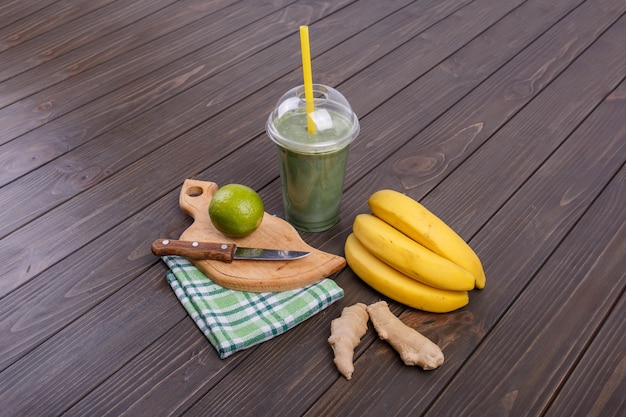 Здоровый коктейль с бананами, лаймом и имбирем лежит на столе