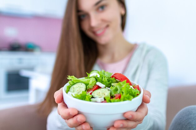 Healthy vegan woman holding a bowl of fresh vegetable salad. balanced organic diet and clean eating