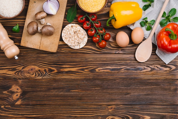 Здоровые овощи; яйца; воздушный пирог и полента на деревянном столе