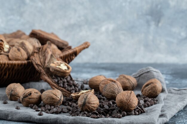 Здоровые грецкие орехи с ароматными кофейными зернами на серой скатерти.