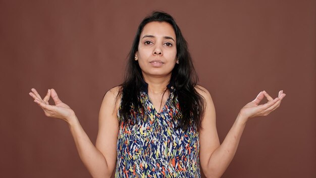 Healthy woman meditating in front of camera with yoga pose, feeling zen about meditation concept. Using concentration to meditate for mindfulness and peaceful energy, positive peace.