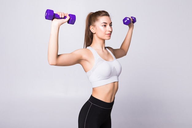 Free photo healthy woman with dumbbells working out isolated on white wall. fitness gym concept