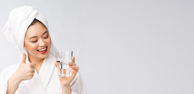 Здоровая молодая красивая женщина пьет воду красоты лица естественный макияж, изолированные на белом фоне