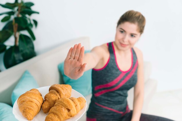 Healthy young woman showing no sign to the croissant