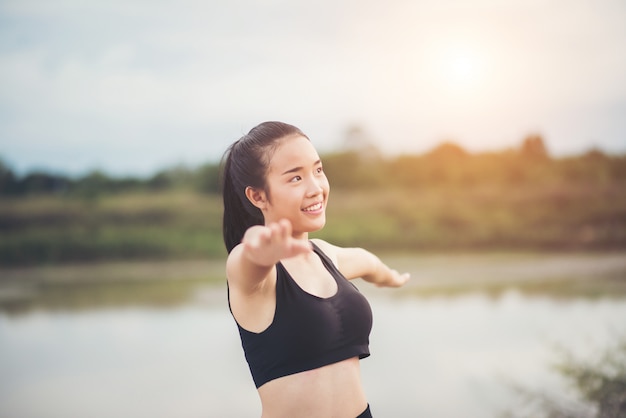 건강 한 젊은 여자는 공원에서 훈련 세션 전에 야외 운동을 워밍업.