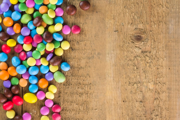 Heap of candy buttons on timber background