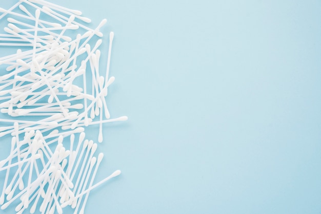 Free photo heap of cotton swabs on blue background