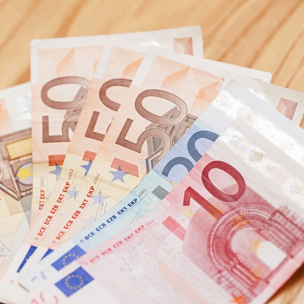 Куча банкнот евро на деревянном столе
