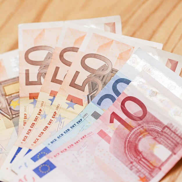 Heap of euro banknotes on a wooden table 