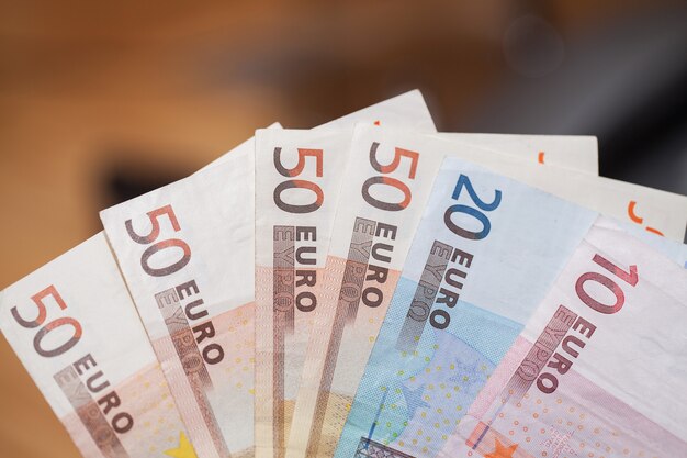 Heap of euro banknotes on a wooden table 