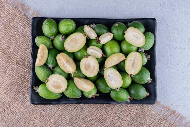 대리석 배경에 검은 접시에 feijoas의 힙. 고품질 사진