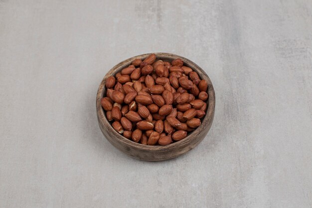 Heap of fresh peanuts in wooden bowl.