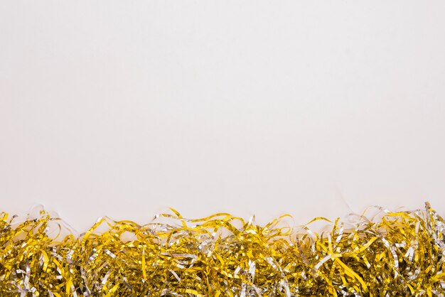 Heap of gold tinsel on white background