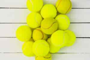 Foto gratuita mucchio di palline da tennis verde sul tavolo di legno