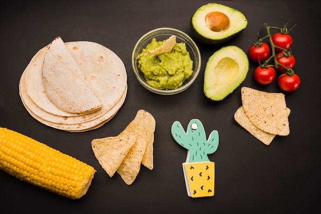 Heap of pita near vegetables and guacamole sauce with nachos