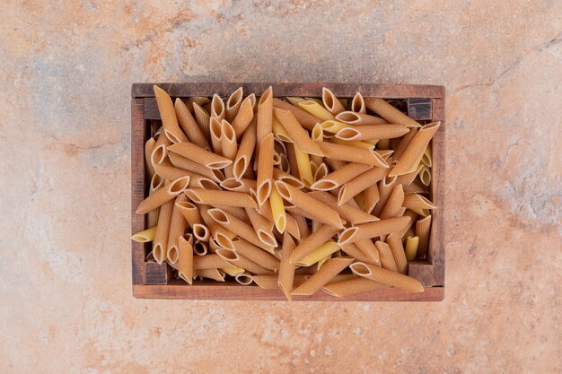 Heap of raw fresh pasta on wooden basket. High quality photo