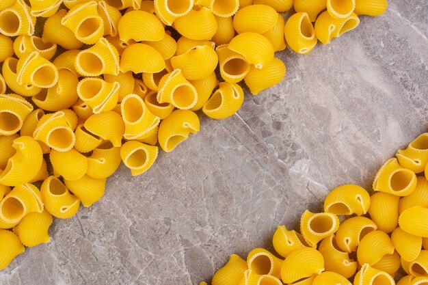 Heap of raw pipe pasta, on the marble.