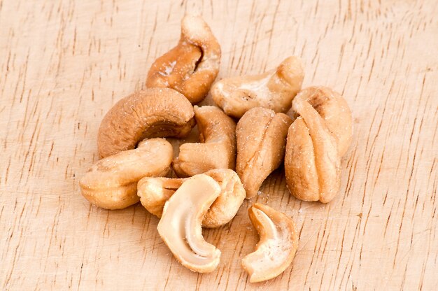 Heap of a roasted cashew nuts on an old wooden table.