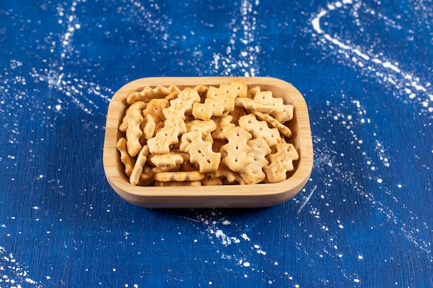 Free photo heap of salty small crackers placed in wooden bowl