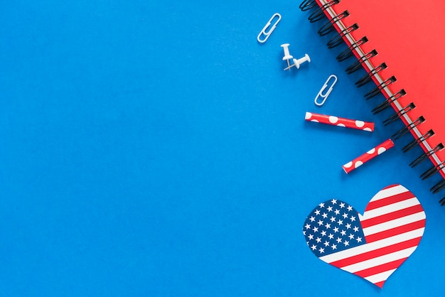 Heart in American flag color and stationery on blue surface