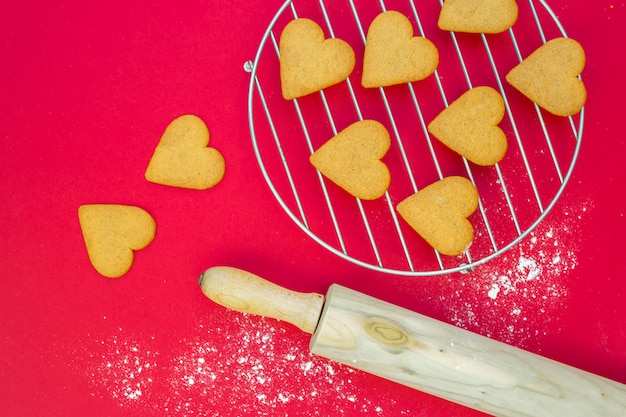 Free photo heart biscuits near rolling pin and grill