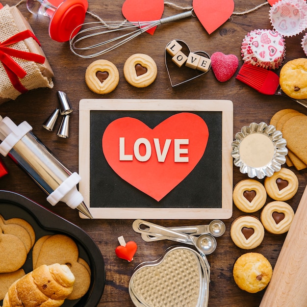 Heart on blackboard amidst astry and bakeware