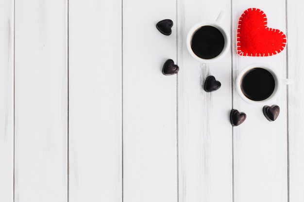 Cuore e caramelle vicino a tazze di caffè