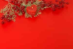 Free photo heart candle with red berries on table