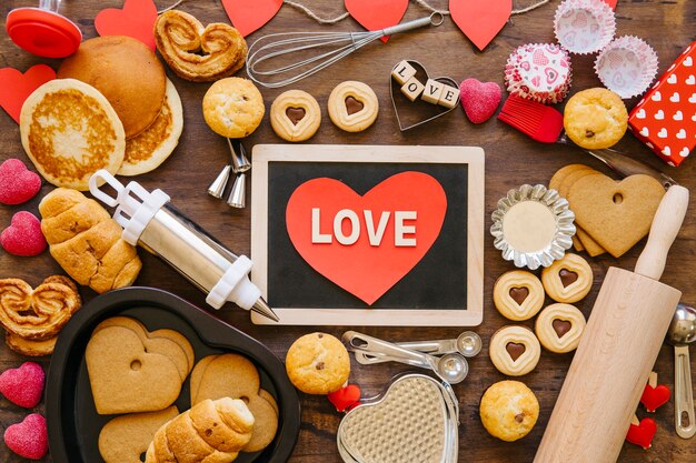 Heart and chalkboard amidst bakeware and pastry