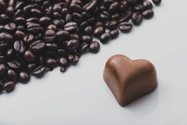 Heart of chocolate next to coffee beans