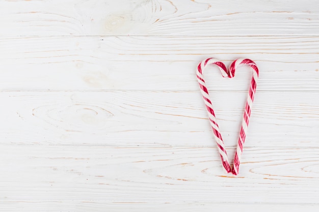 Heart made from candy canes on table