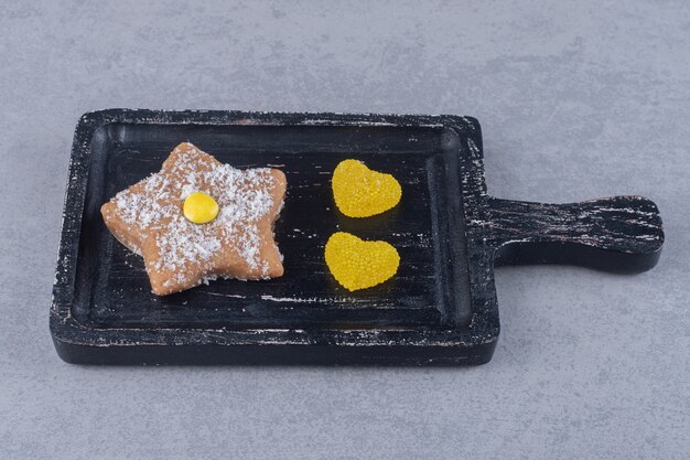 Heart marmelades and star cookie on a tray on marble surface