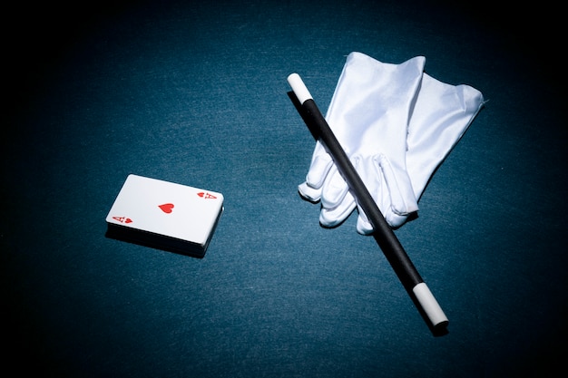 하트 모양 에이스 카드; 마술 지팡이와 포커 테이블 위에 장갑의 흰색 쌍