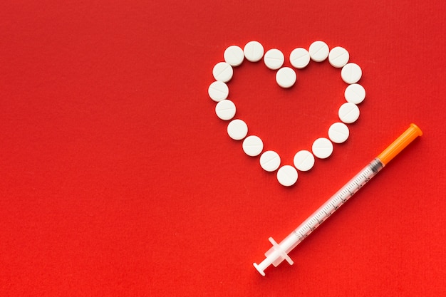 Heart shape from pills and syringe