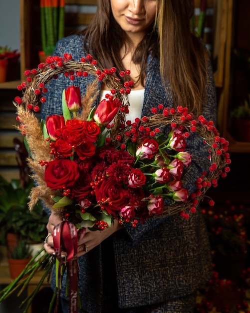 Free photo heart shaped bouquet of red tulips and roses