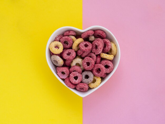 heart shaped bowl filled with pink and yellow fruit loops