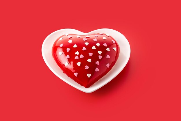Торт в форме сердца на День святого Валентина или день матери на красном фоне.