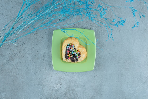 Heart-shaped cake with chocolate and candy filling on a platter on marble background. High quality photo