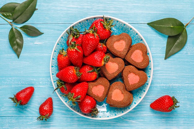 Heart shaped chocolate and strawberry cookies with fresh strawberries,top view
