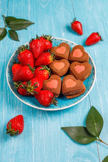 Heart shaped chocolate and strawberry cookies with fresh strawberries,top view