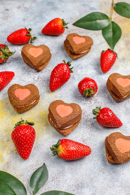 Free photo heart shaped chocolate and strawberry cookies with fresh strawberries, top view