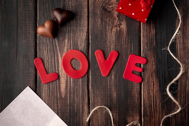 Heart-shaped chocolates on wooden background with love