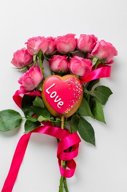 Печенье в форме сердца на палочке с букетом роз
