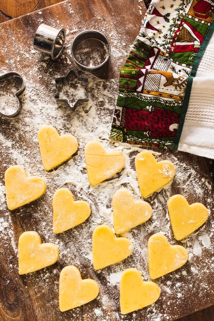 Heart-shaped cookies near towel and cutters
