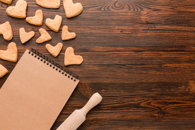 Heart-shaped cookies for valentines day with notebook and rolling pin